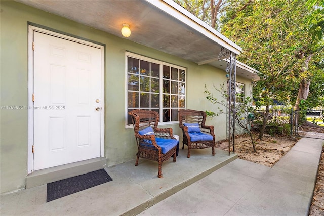 entrance to property with stucco siding and fence