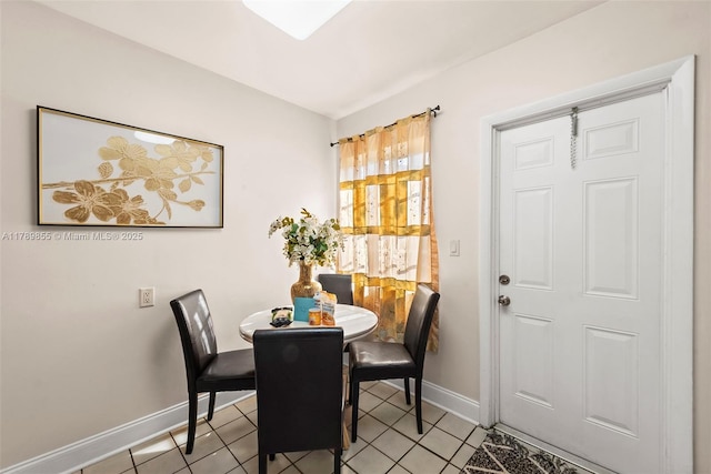 dining space featuring baseboards and light tile patterned flooring