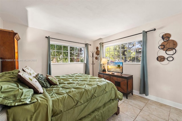bedroom featuring light tile patterned floors and baseboards