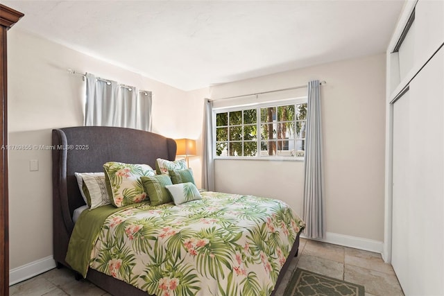bedroom featuring baseboards and stone finish floor