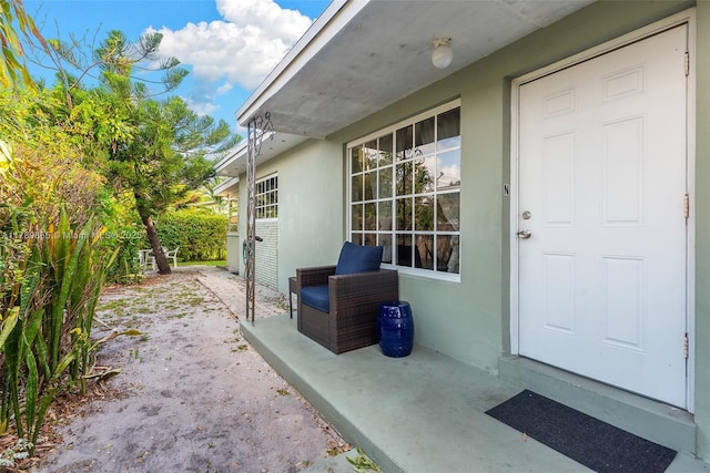 doorway to property featuring stucco siding