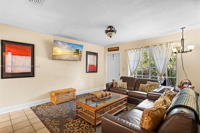 tiled living area featuring an inviting chandelier, baseboards, and visible vents