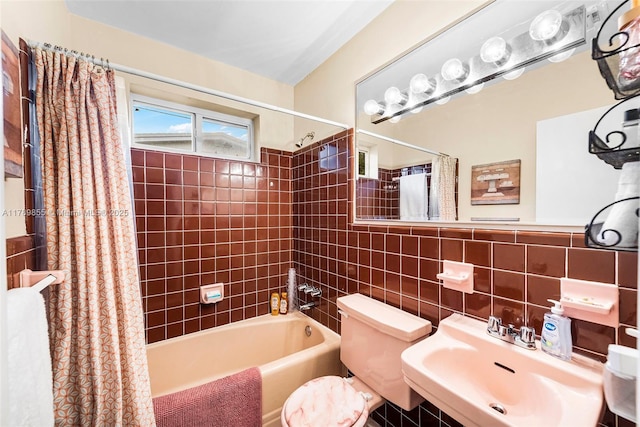 full bathroom featuring a sink, shower / bath combo, toilet, and tile walls
