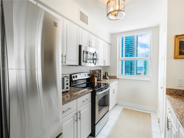 1155 Brickell Bay Dr Unit 2101, Miami, FL 33131 - kitchen with visible vents, stainless steel appliances, stone counters, and white cabinets