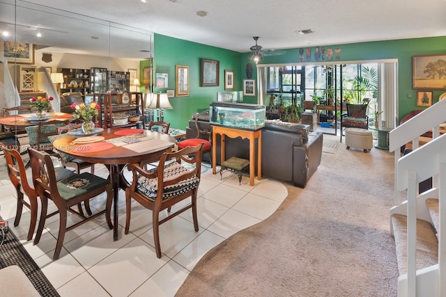 tiled dining area featuring ceiling fan and stairs