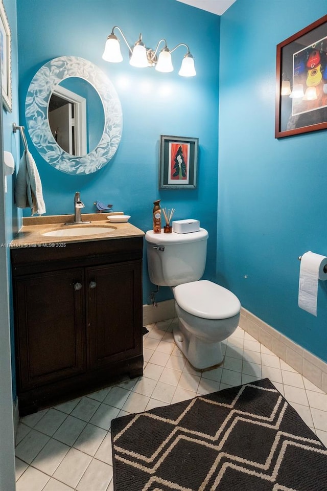 half bath featuring tile patterned floors, baseboards, toilet, and vanity
