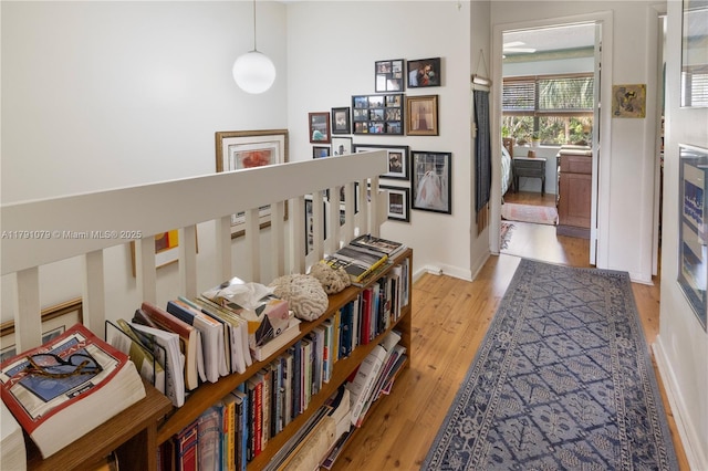 hallway with light wood-type flooring and baseboards