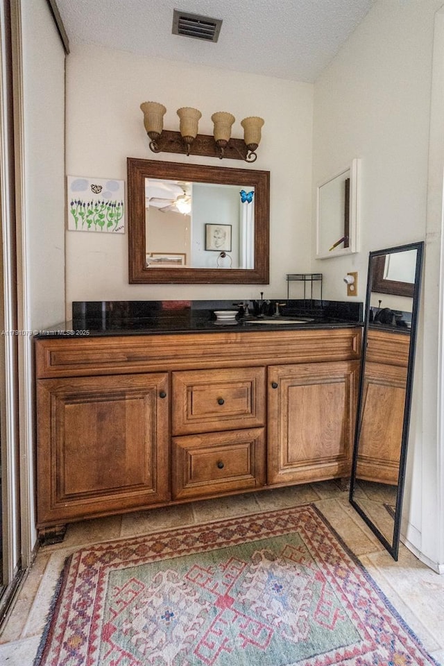 bathroom featuring visible vents, a textured ceiling, and vanity