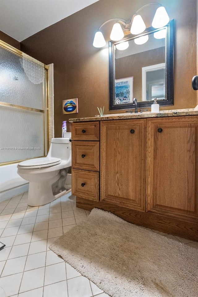 bathroom featuring shower / bath combination with glass door, vanity, toilet, and tile patterned flooring