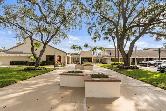 view of front of house with stucco siding and a front lawn