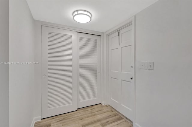 interior space with baseboards and light wood-type flooring