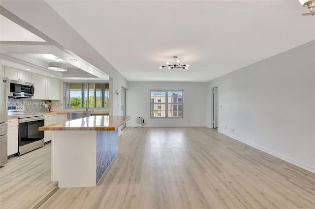 kitchen featuring an inviting chandelier, plenty of natural light, white cabinetry, and appliances with stainless steel finishes