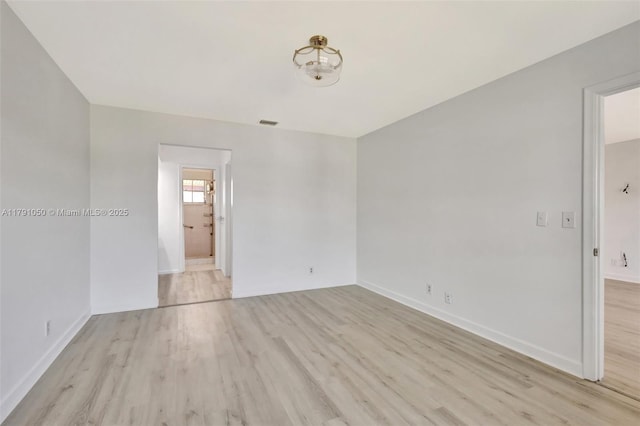 spare room featuring baseboards and wood finished floors