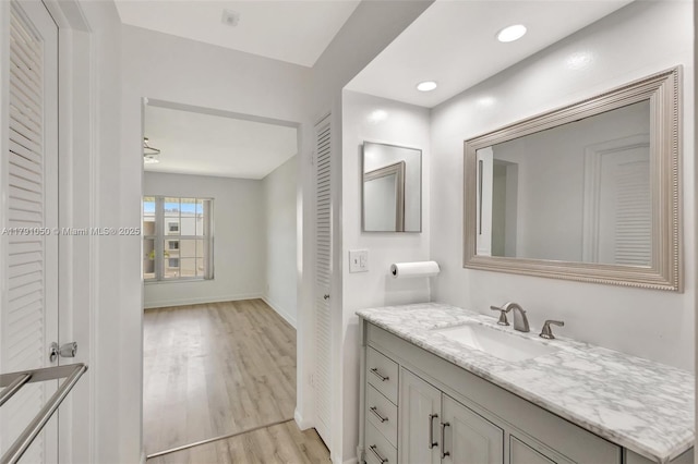 bathroom featuring baseboards, wood finished floors, and vanity