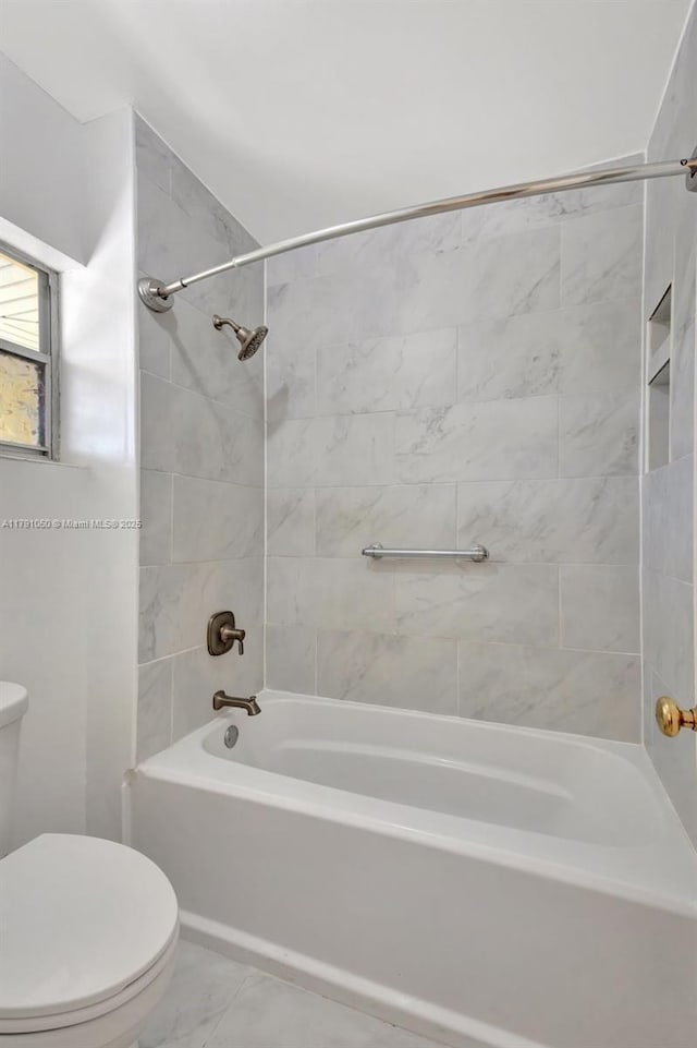 full bath featuring bathing tub / shower combination, toilet, and marble finish floor