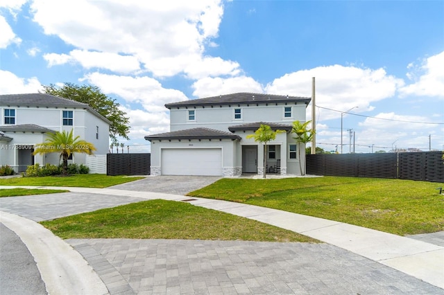 view of front of home featuring stucco siding, decorative driveway, fence, and a front lawn