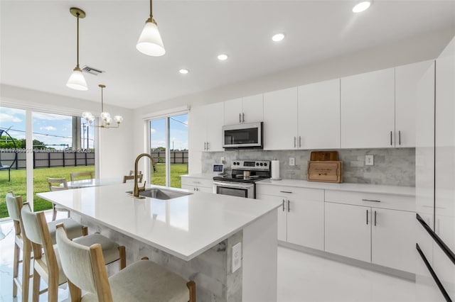kitchen featuring visible vents, a sink, appliances with stainless steel finishes, and a healthy amount of sunlight