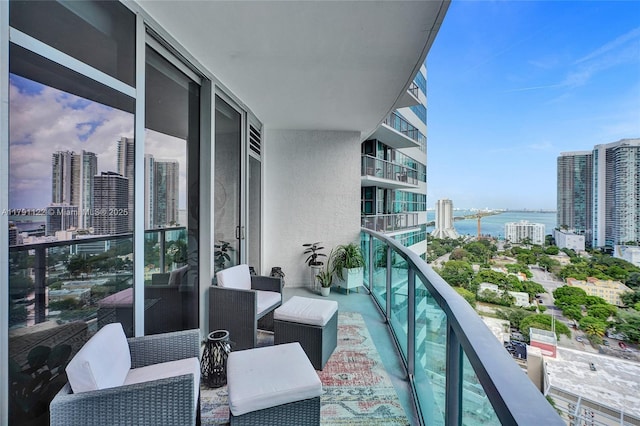 balcony with central AC, a city view, and a water view