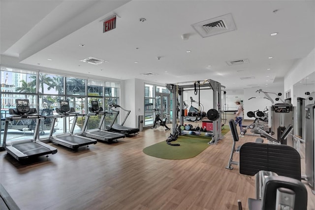 exercise room featuring light wood finished floors, recessed lighting, and visible vents