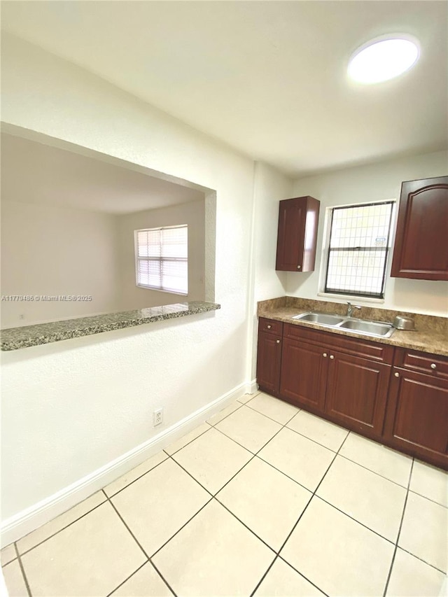 4160 NW 21st St Unit 216-E, Lauderhill, FL 33313 - kitchen with baseboards, a sink, light tile patterned flooring, and dark brown cabinets