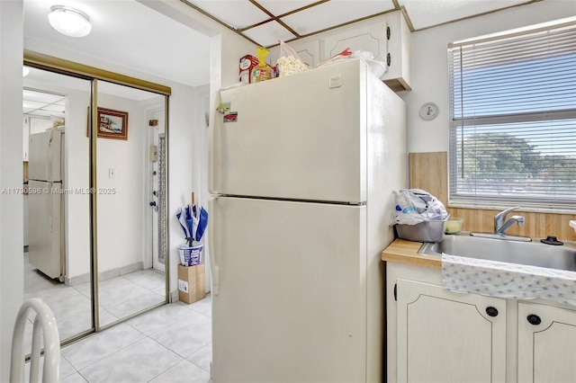 9281 Sunrise Lakes Blvd Unit 306, Sunrise, FL 33322 - kitchen featuring freestanding refrigerator, a sink, light countertops, and white cabinetry