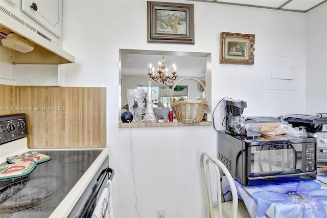 9281 Sunrise Lakes Blvd Unit 306, Sunrise, FL 33322 - kitchen with electric range oven, under cabinet range hood, a chandelier, and black microwave