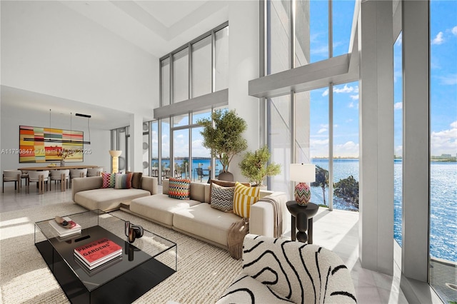 living room with a high ceiling and a water view