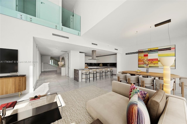 living area featuring visible vents and marble finish floor
