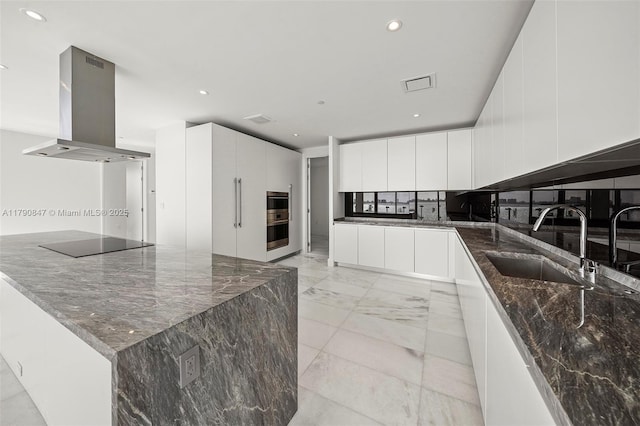 kitchen featuring black electric stovetop, a sink, stainless steel double oven, island exhaust hood, and modern cabinets