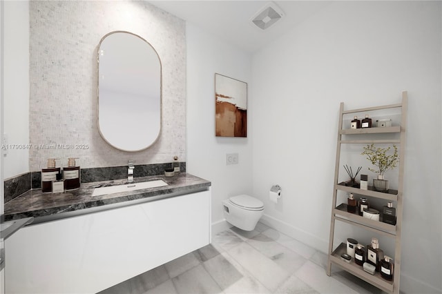 bathroom featuring vanity, toilet, marble finish floor, visible vents, and baseboards