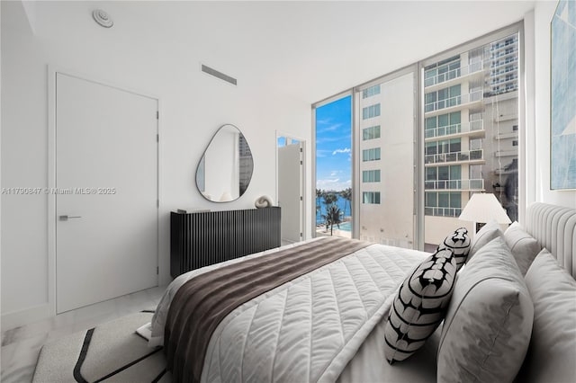 bedroom with floor to ceiling windows, visible vents, marble finish floor, and access to outside