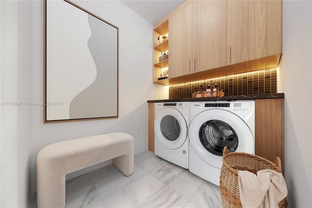 laundry room featuring marble finish floor, cabinet space, and washer and clothes dryer