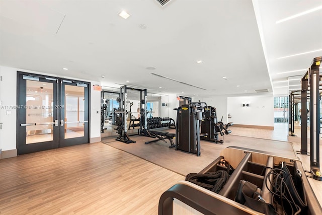 workout area with wood finished floors and french doors
