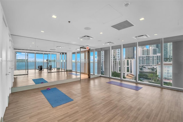 700 NE 26th Ter Unit Th-403, Miami, FL 33137 - exercise room featuring a wall of windows, wood finished floors, and a water view
