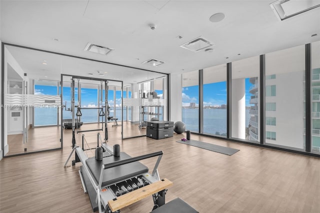 700 NE 26th Ter Unit Th-403, Miami, FL 33137 - exercise room featuring floor to ceiling windows, wood finished floors, and a water view