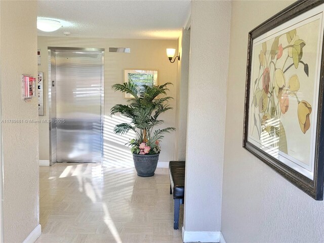 7080 Environ Blvd Unit 424, Lauderhill, FL 33319 - hall featuring elevator, a textured wall, and baseboards