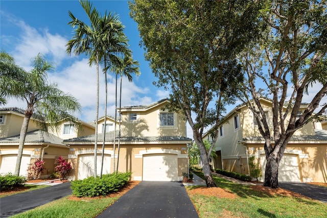 view of front of property featuring stucco siding, a garage, and aphalt driveway