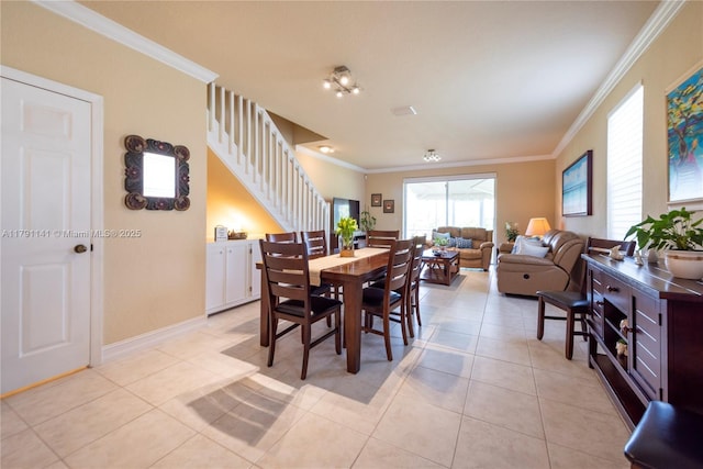 dining area featuring light tile patterned floors, ornamental molding, and stairs