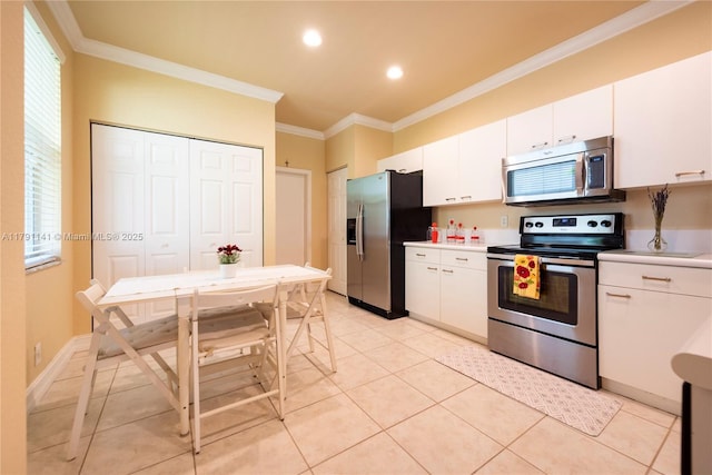 kitchen featuring light countertops, appliances with stainless steel finishes, ornamental molding, and white cabinetry