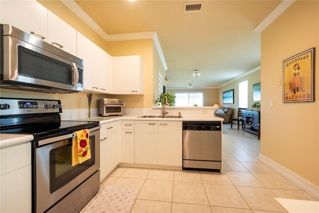 kitchen with crown molding, visible vents, open floor plan, a sink, and stainless steel appliances