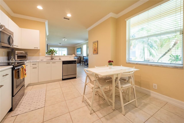 kitchen featuring visible vents, crown molding, a peninsula, a sink, and appliances with stainless steel finishes