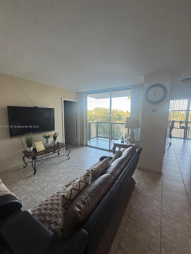 11750 SW 18th St Unit 406-1, Miami, FL 33175 - living room featuring tile patterned flooring, a textured ceiling, and expansive windows