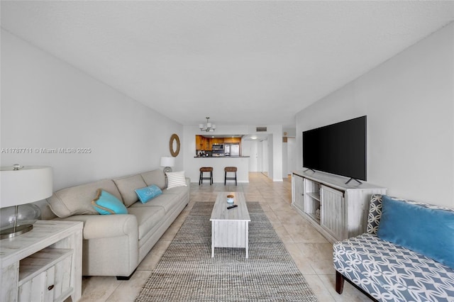 living room with light tile patterned floors, a notable chandelier, and visible vents