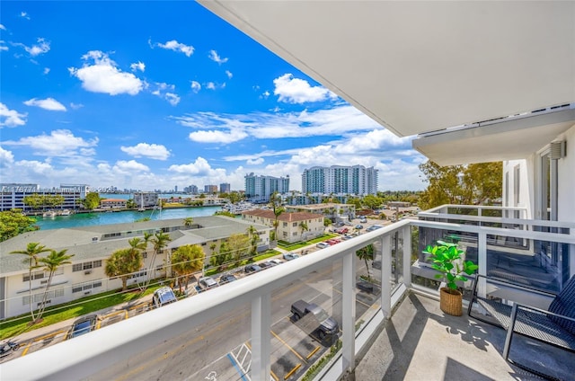 balcony featuring a water view and a city view