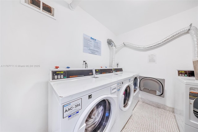 shared laundry area with tile patterned flooring, washer and dryer, and visible vents