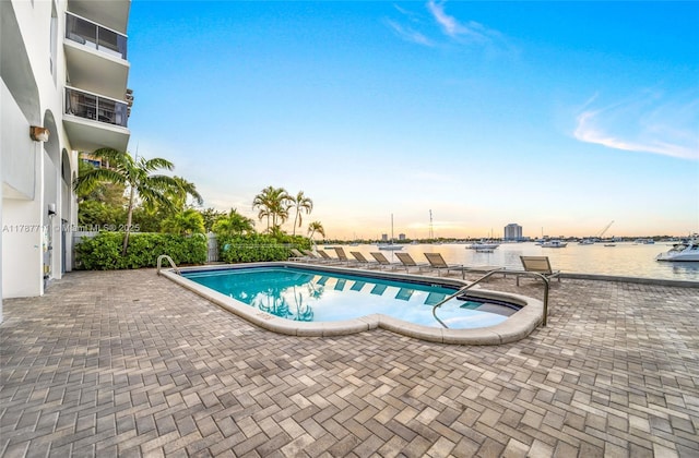 community pool featuring a water view and a patio