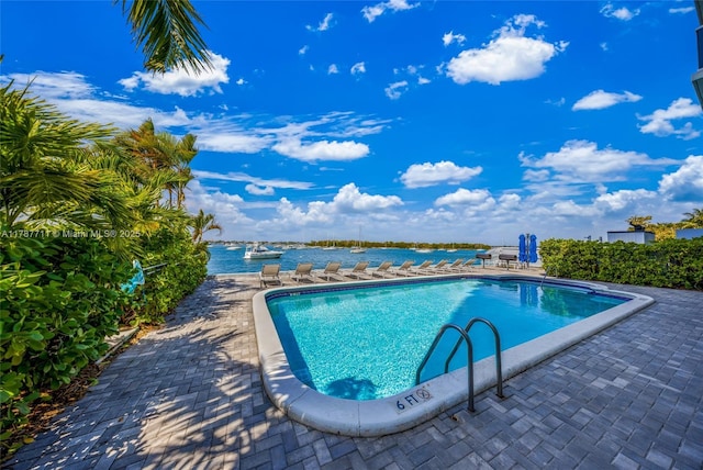 pool with a water view and a patio