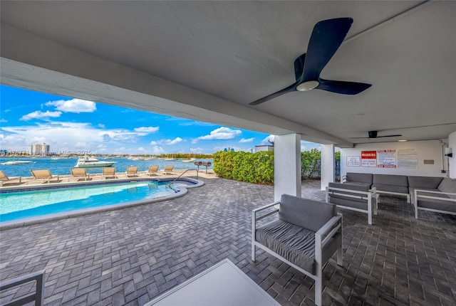 view of patio with outdoor lounge area, a ceiling fan, a community pool, and a hot tub