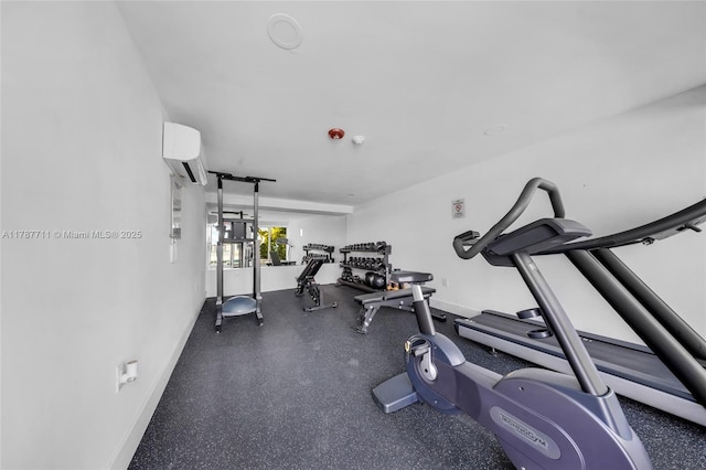 exercise room featuring a wall mounted AC and baseboards