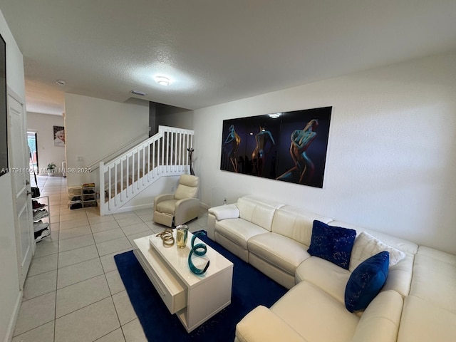 tiled living area featuring stairs, visible vents, and a textured ceiling